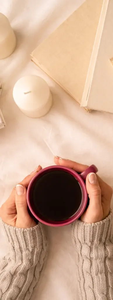 Hände, die eine Tasse Kaffee umschließen